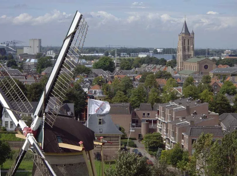 foto van  bovenaf van een stad met molen, huizen en een kerk