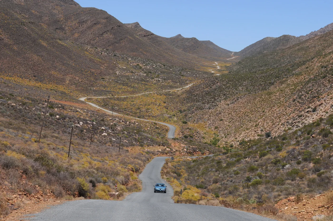 ‍foto: Tom van der Leij van landschap Zuid-Afrika met weg erdoorheen en auto erop