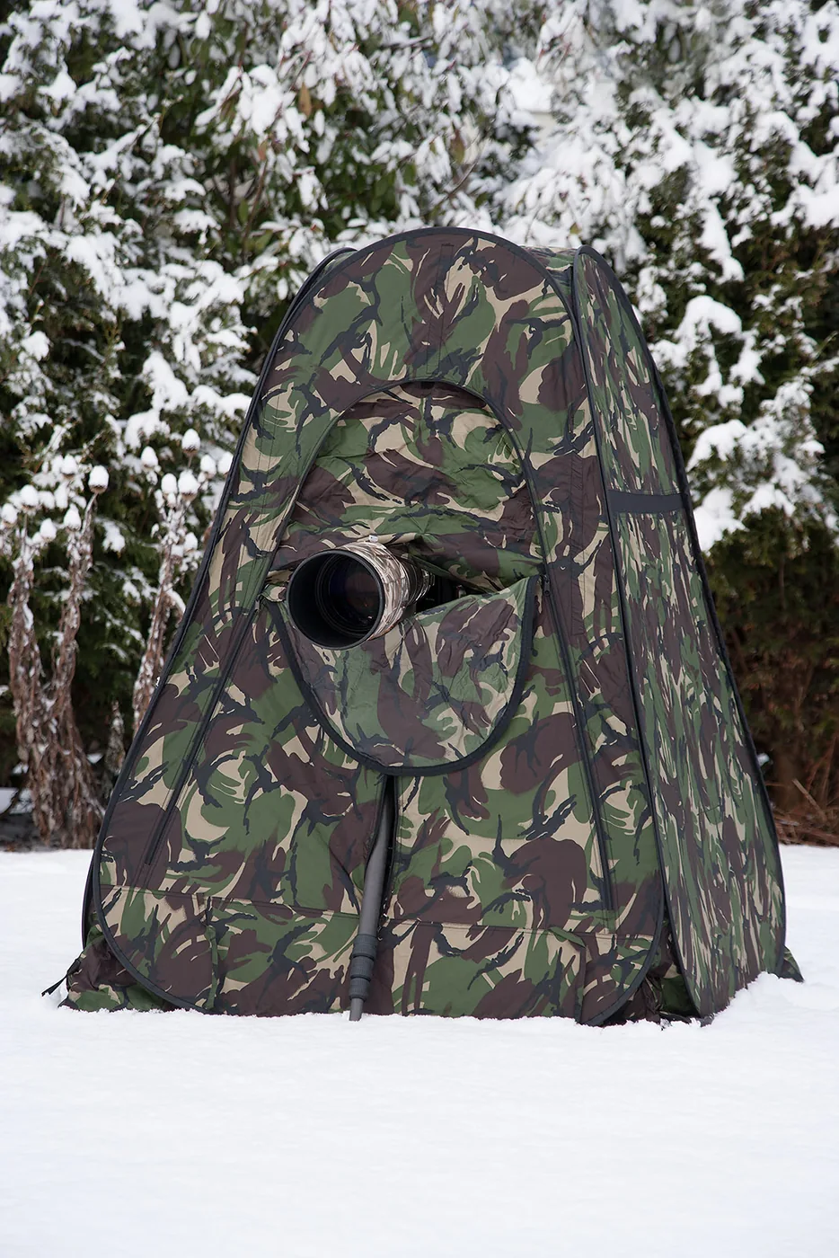 foto van een camouflagetent met camera in de sneeuw