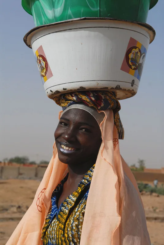 photo: Tom van der Leij — woman carrying pots on her head in Niger