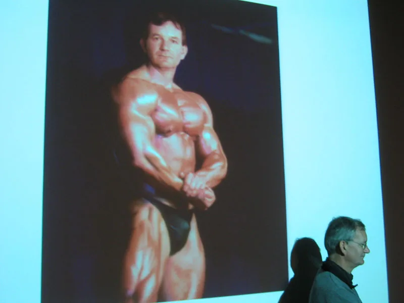 Photo: Fotografie.nl | Martin Parr during a Fotoacademie lecture, with a bodybuilder photo