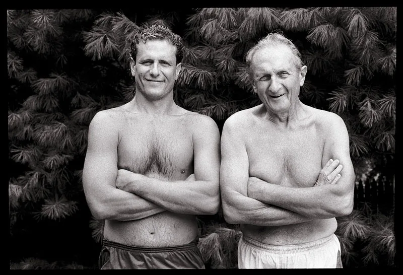 Black and white portrait of two shirtless men standing side by side