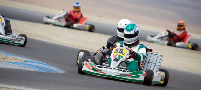 Karters drive around a bend on a race track