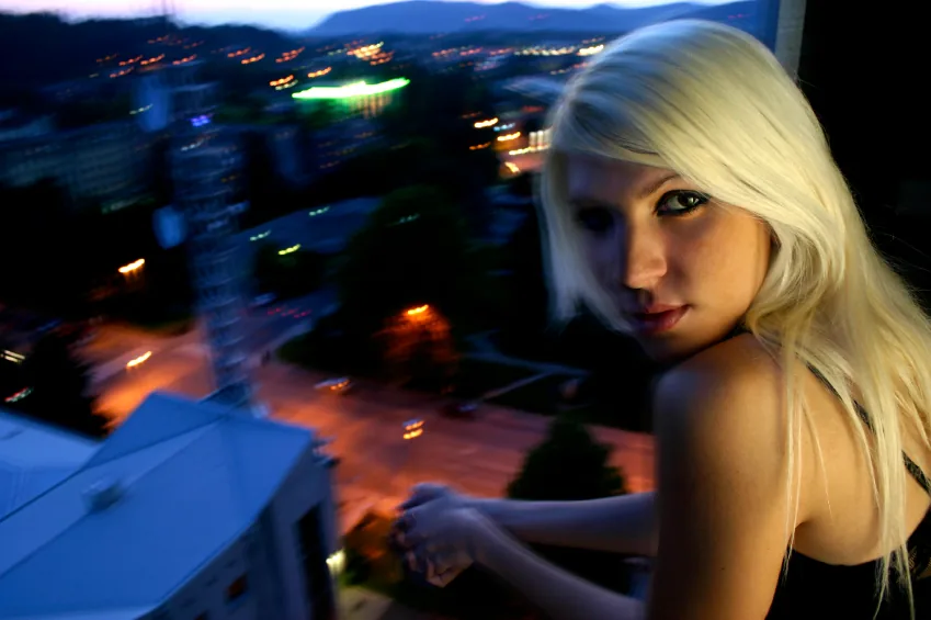 Portrait of a blonde woman at night with motion blur in the background