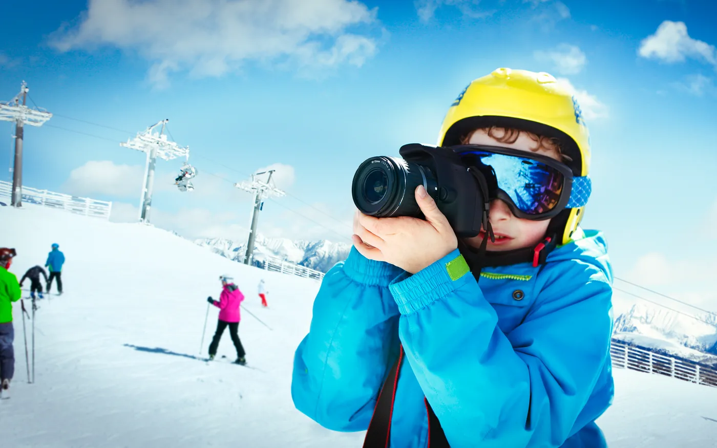 jongen met camera op skipiste
