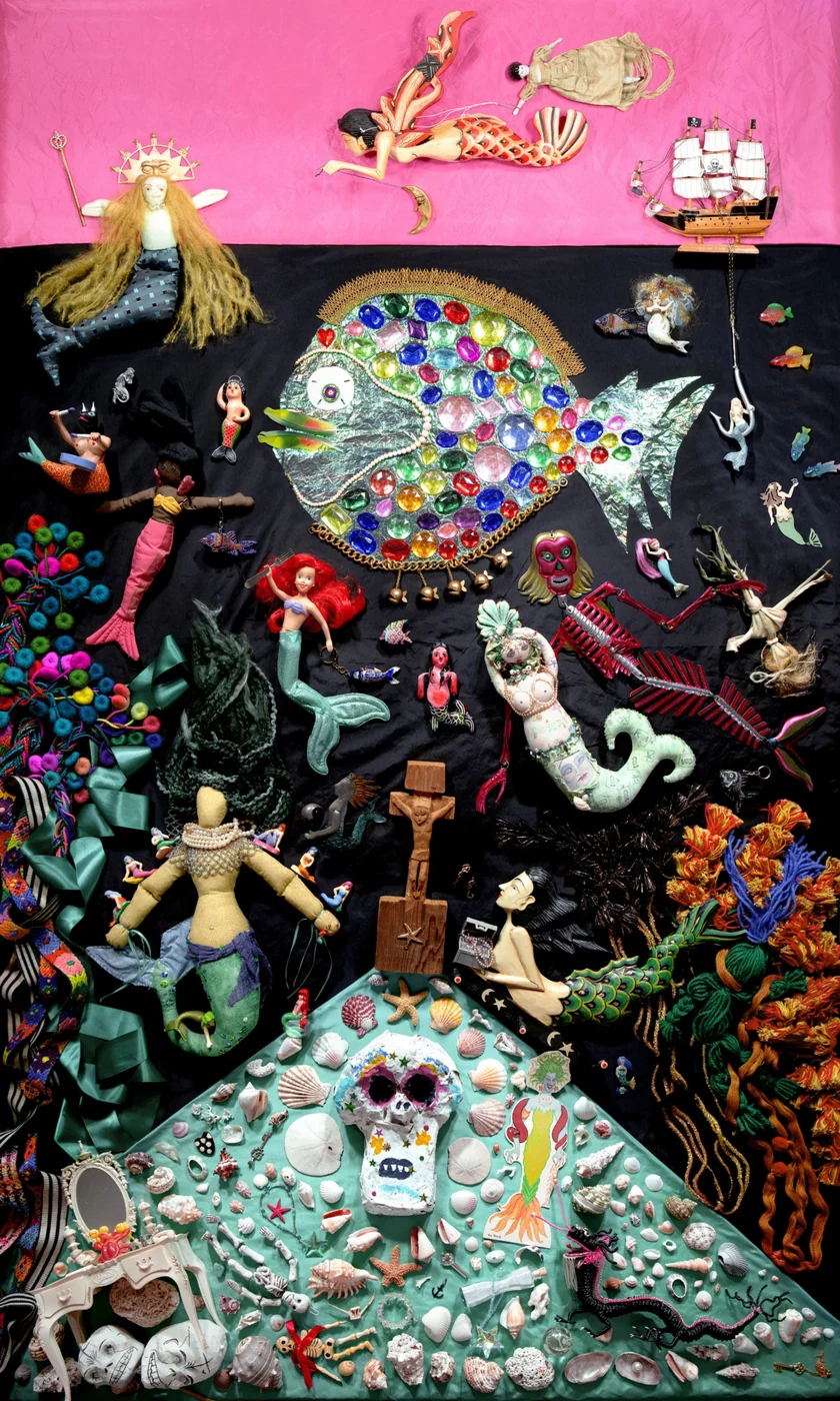 Kleurrijke collage met een grote vis, zeemeerminnen, poppen, schelpen en andere fantasiefiguren op een roze en zwarte achtergrond.