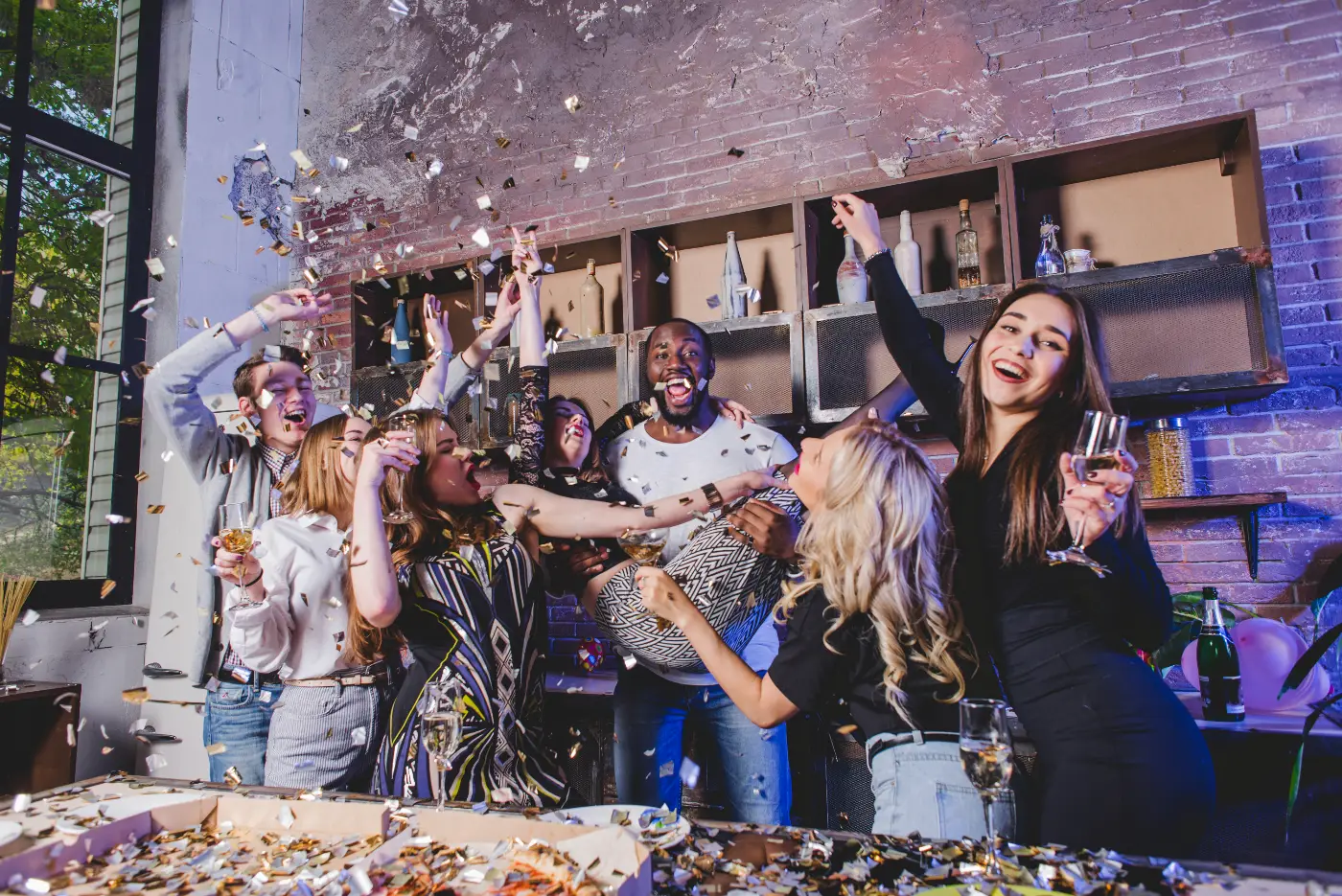 Feestvierende vriendengroep met champagne en confetti, gefotografeerd met flitslicht