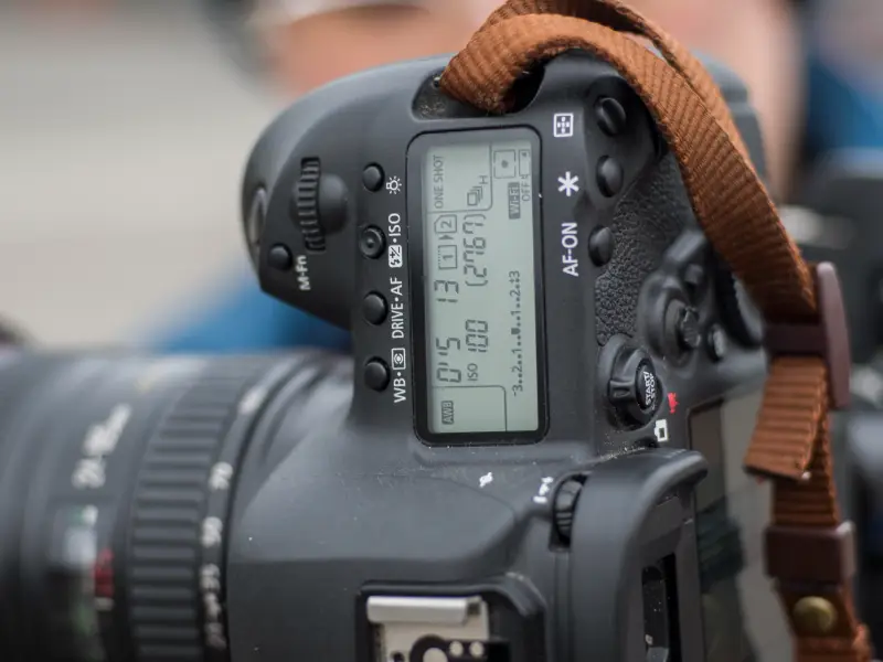 Bovenaanzicht van een Canon-spiegelreflexcamera met objectief en zichtbaar lcd-scherm.