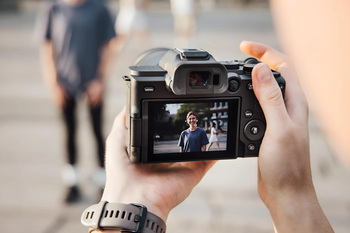 Achterzijde van de Canon EOS R8 Mark II met gezichts- en oogdetectie bij een portret op het scherm.