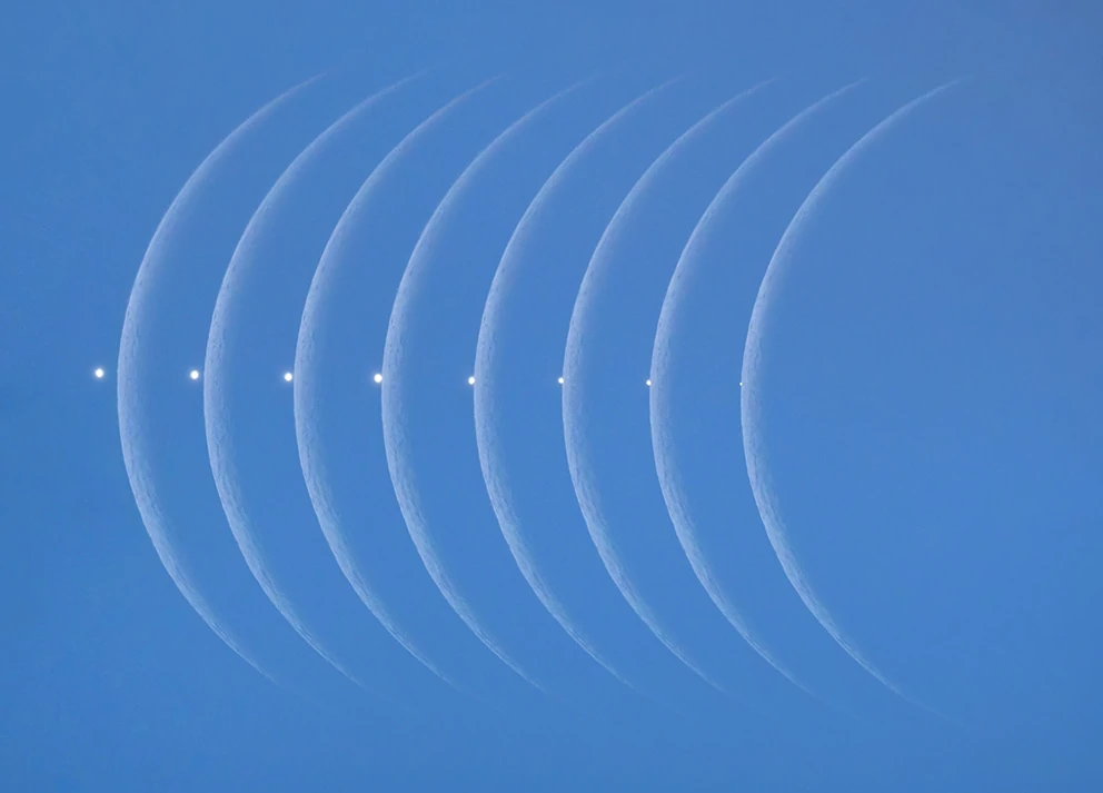 Samengestelde reeks maansikkels tegen een blauwe hemel toont hoe het lichtpuntje Venus achter de maan verdwijnt.
