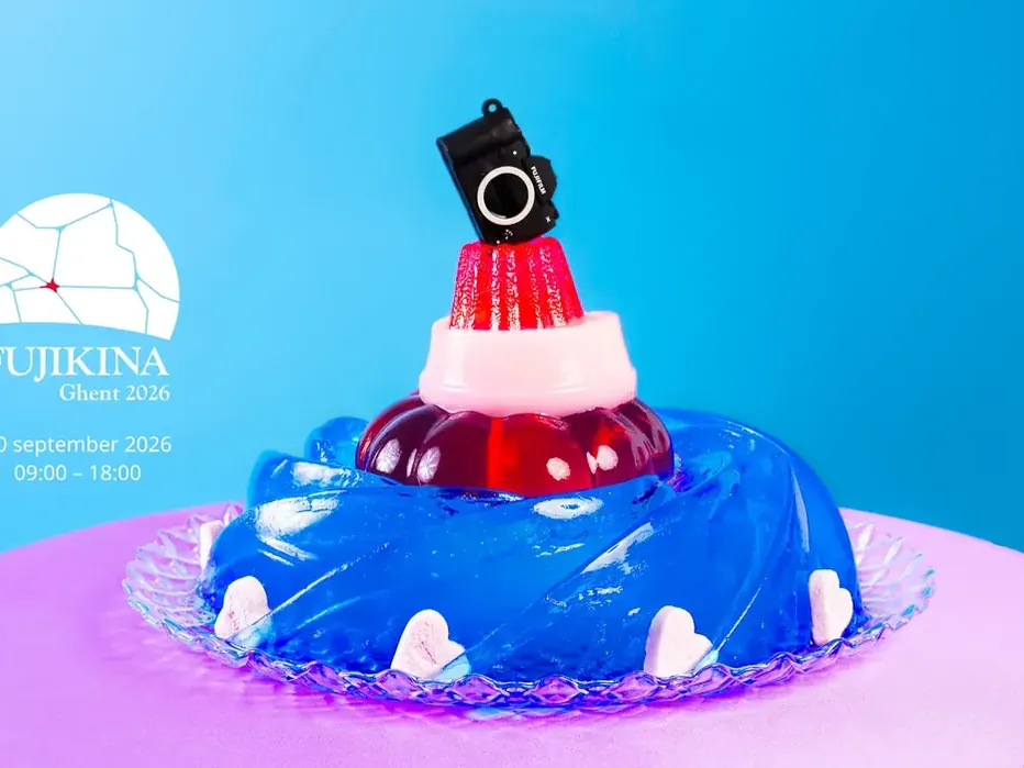Officieel campagnebeeld van FUJIKINA Ghent 2026: een camera op kleurrijke puddinglagen tegen een blauwe achtergrond.