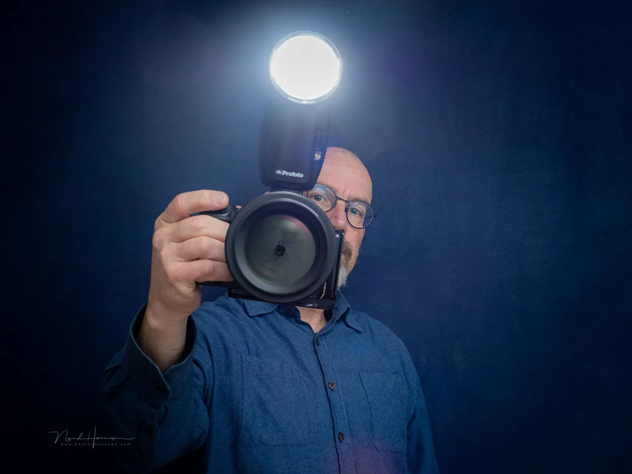 Nando Harmsen met een camera en een brandende reportageflitser