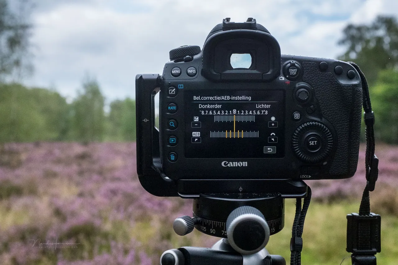 Achterzijde van een camera op statief met belichtingsinstellingen op het scherm