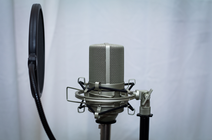 An image of a pop filter positioned 6 inches away from a microphone.