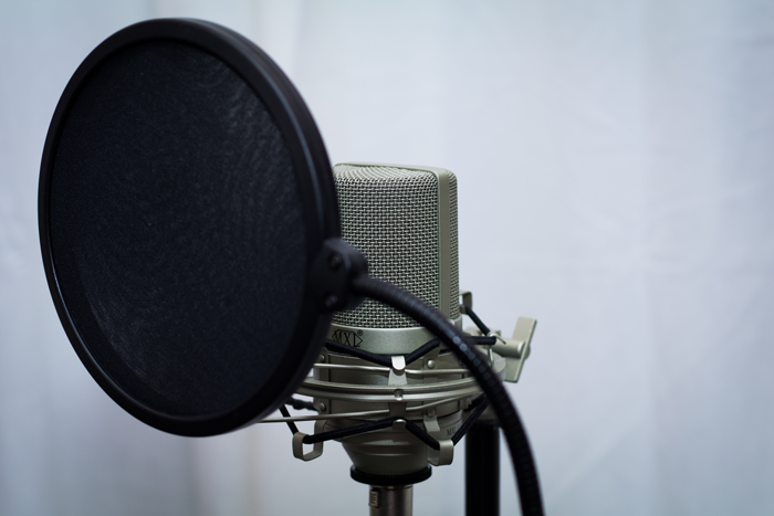 An image of a pop filter attached to a microphone stand.