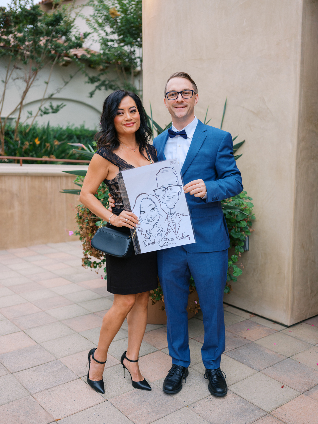Couple pose with their drawn portrait