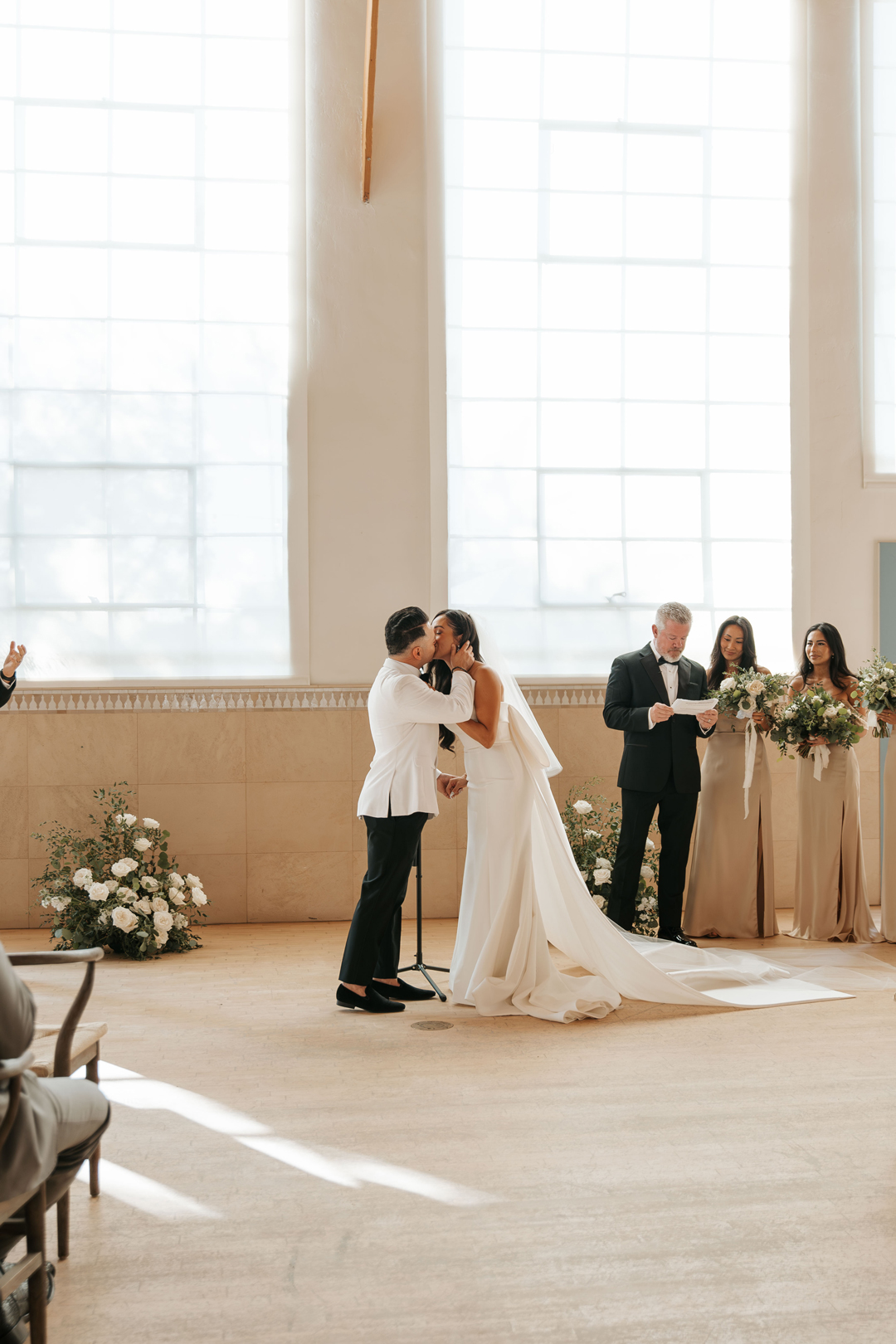 Bride and groom share a ceremony kiss.