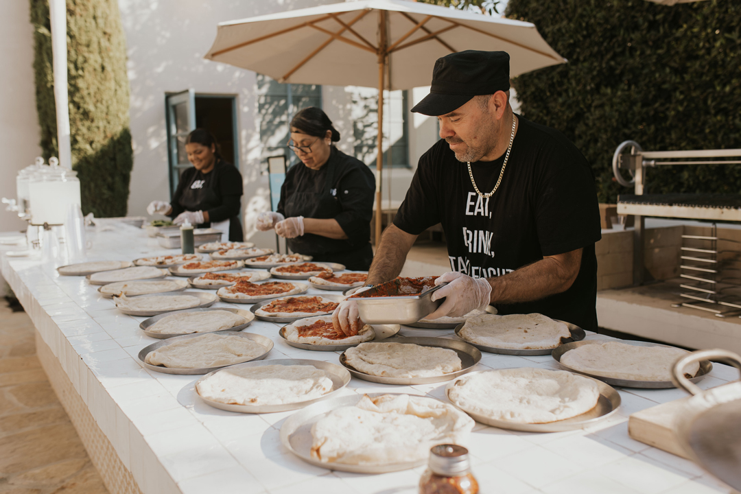 Jay's Catering tops pizza dough for cocktail hour wood-fired pizzas at Grand Gimeno.o