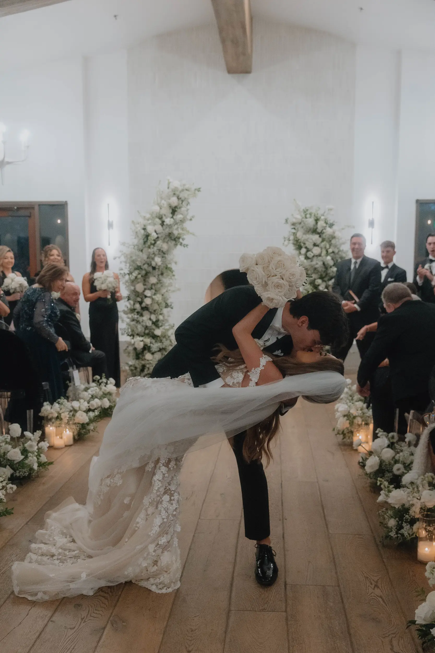 Bride and groom share a kiss as they exit their wedding ceremony.