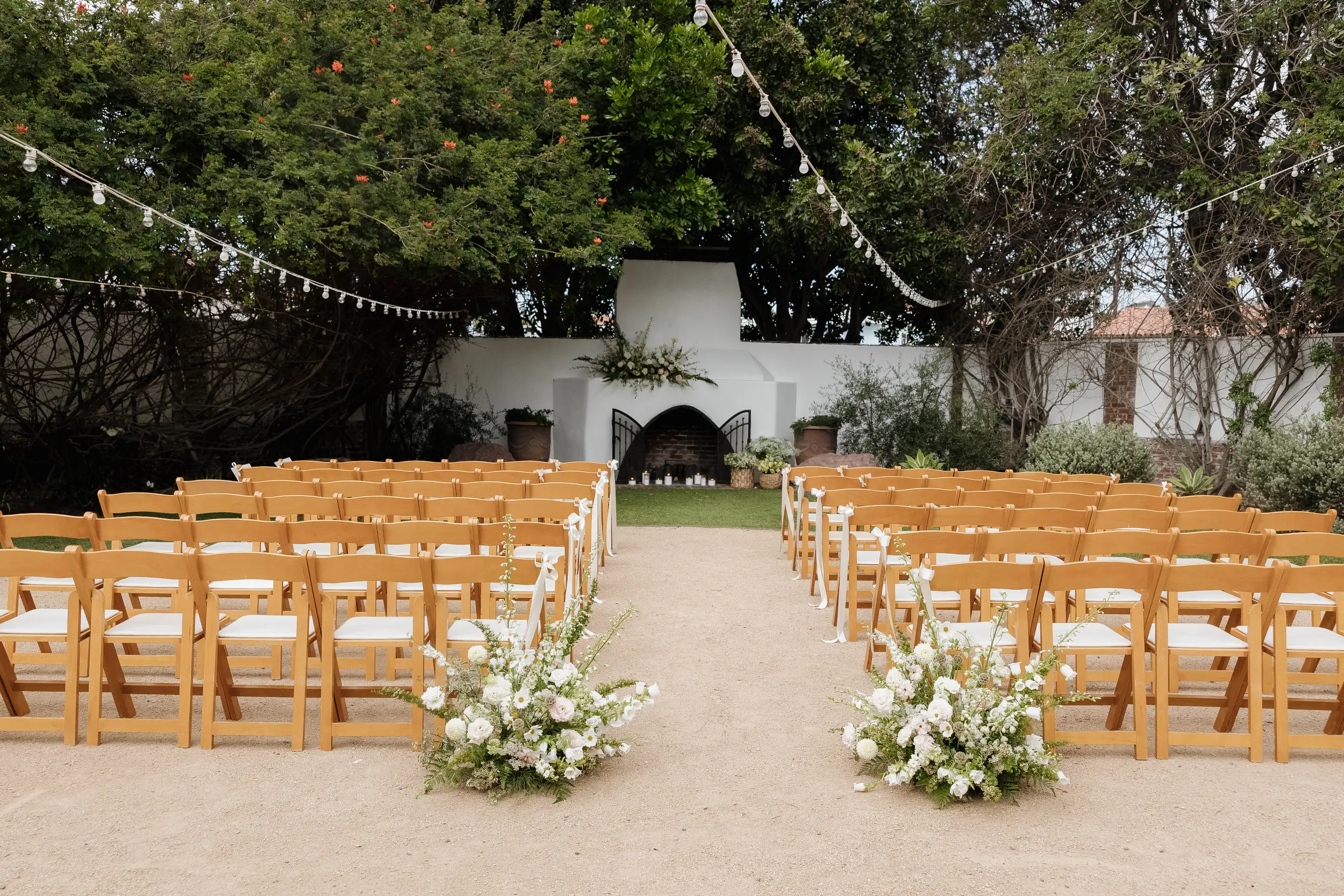 Blush and white flowers decorate the outdoor ceremony space at the Casino San Clemente.