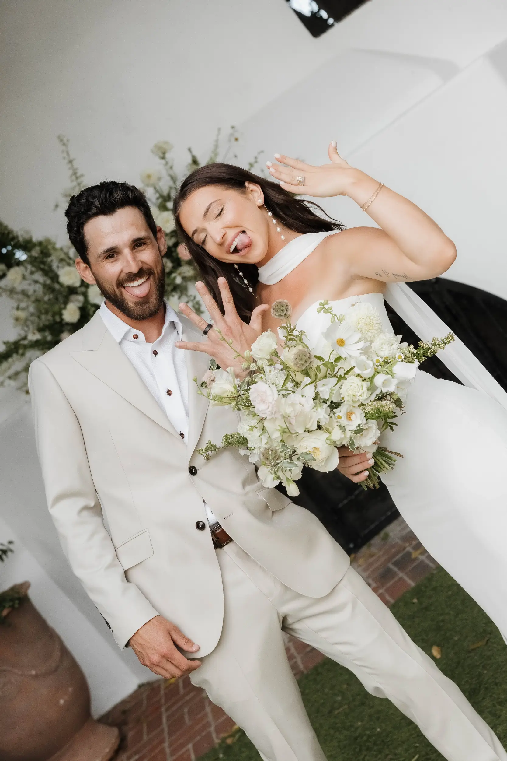 Bride and groom show off their rings after getting married.