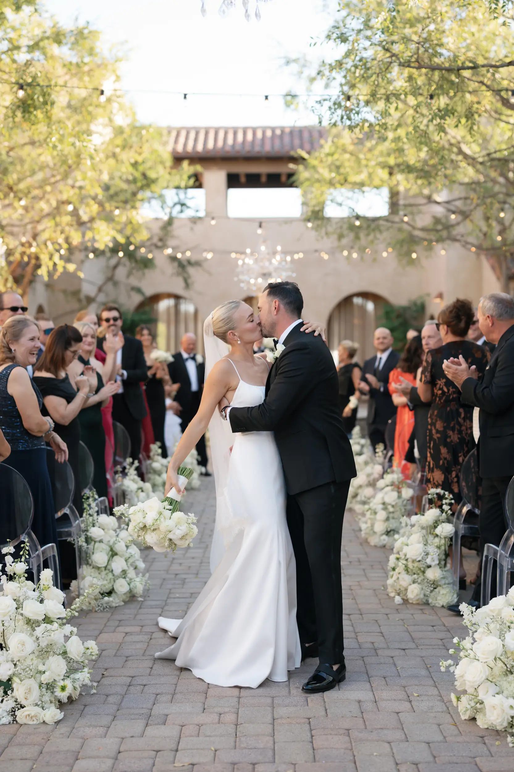 Bride and groom kiss down the aisle.