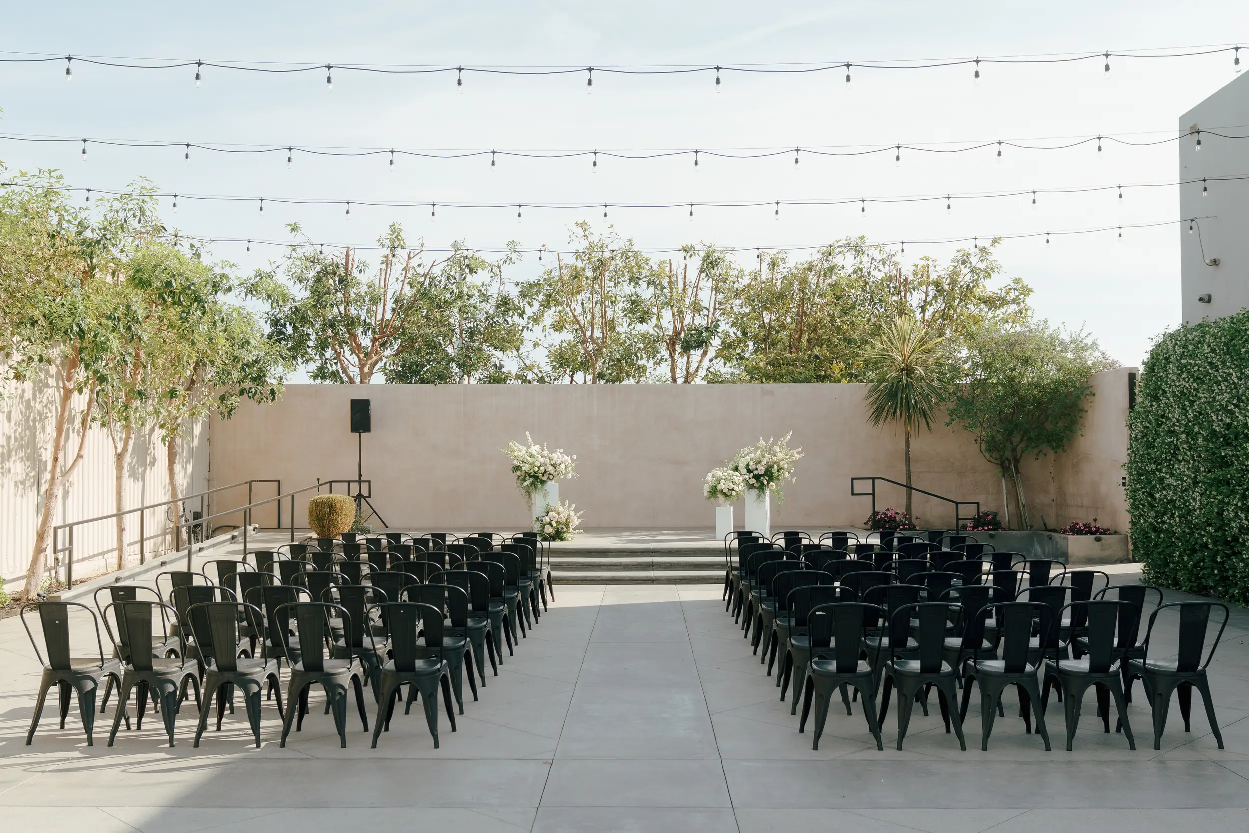 White and peach florals decorate the outdoor wedding ceremony at Hangar 21 South.