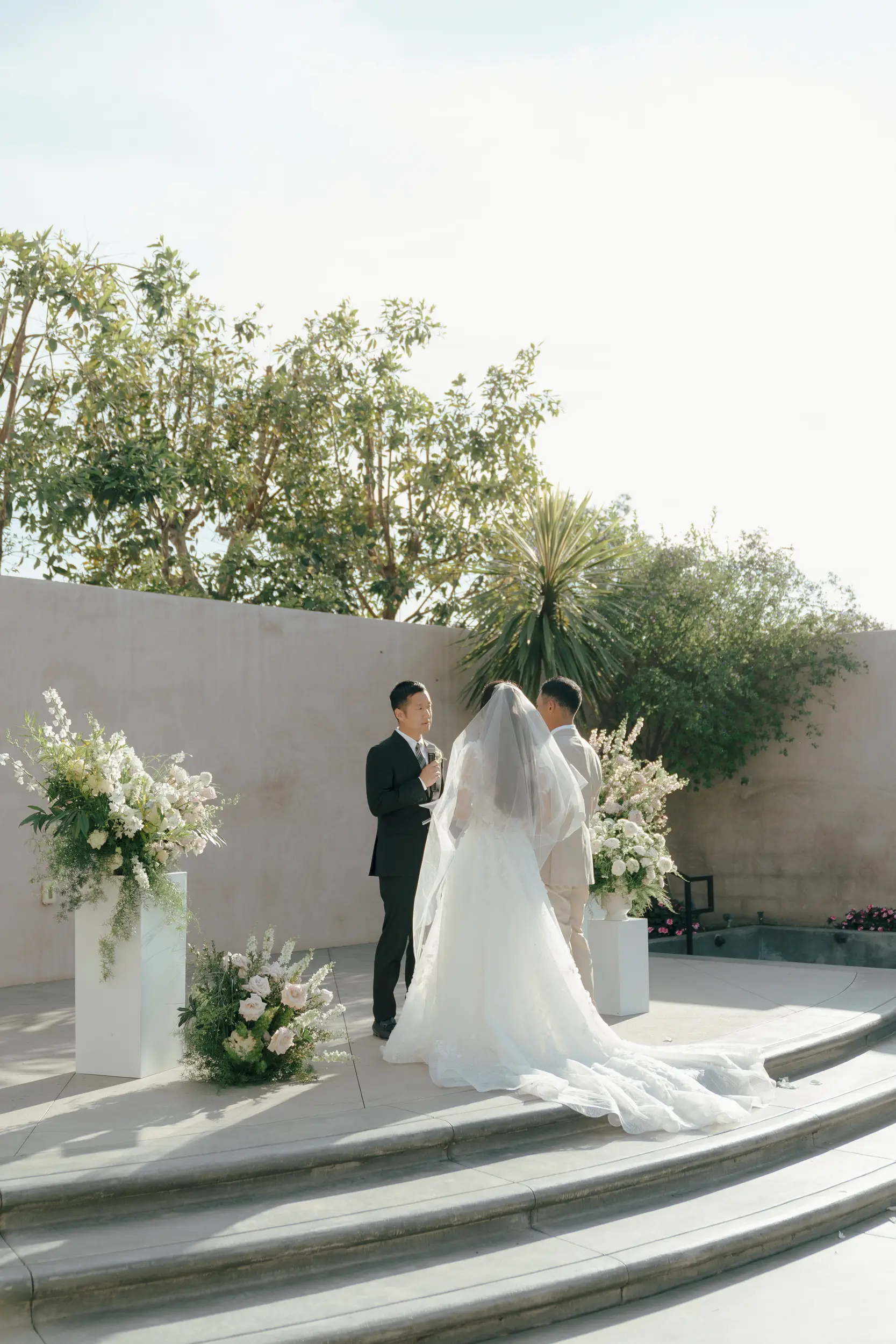 Bride and groom recite vows on stage on the side patio at Hangar 21.