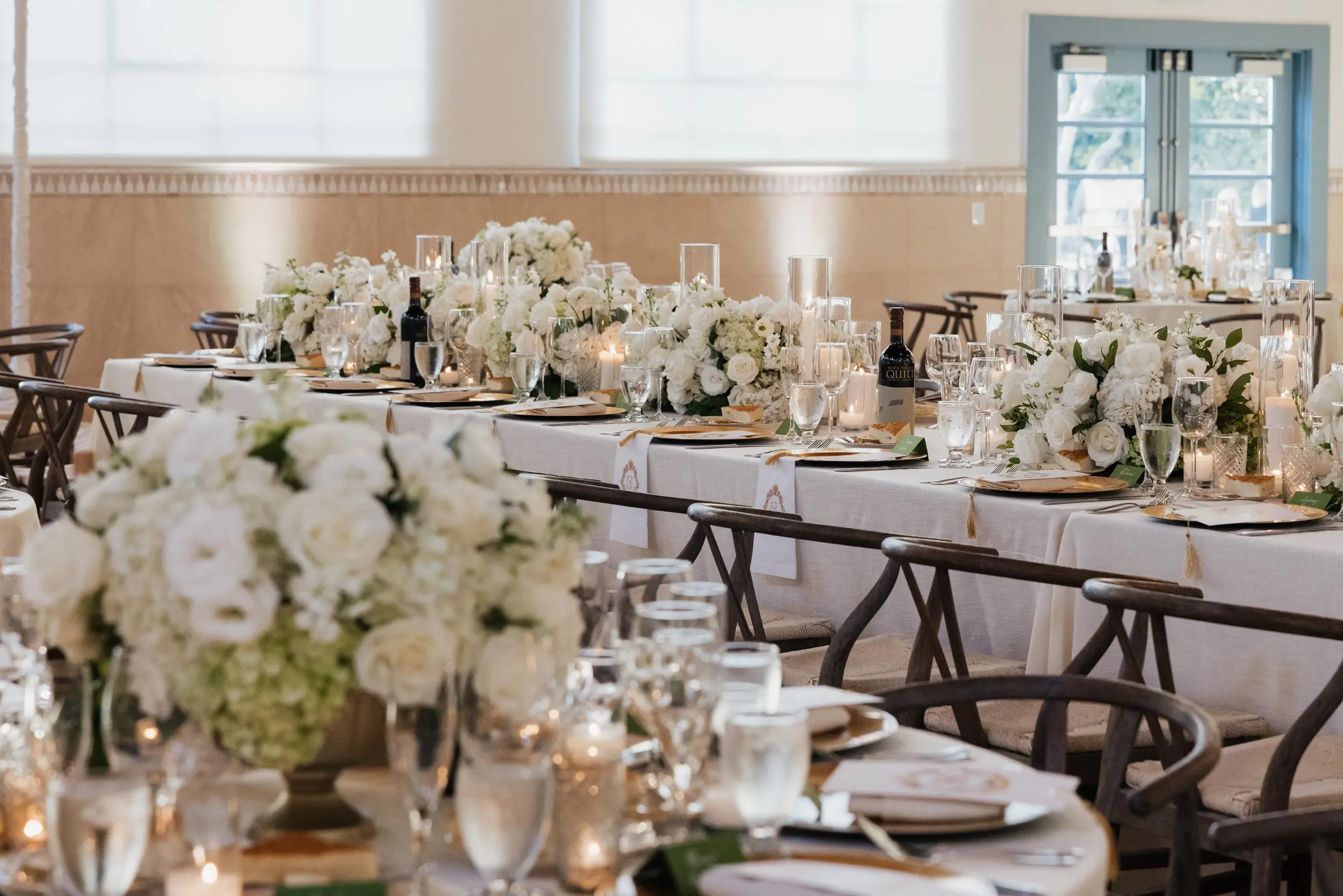 White floral centerpieces top each reception table inside Grand Gimeno.