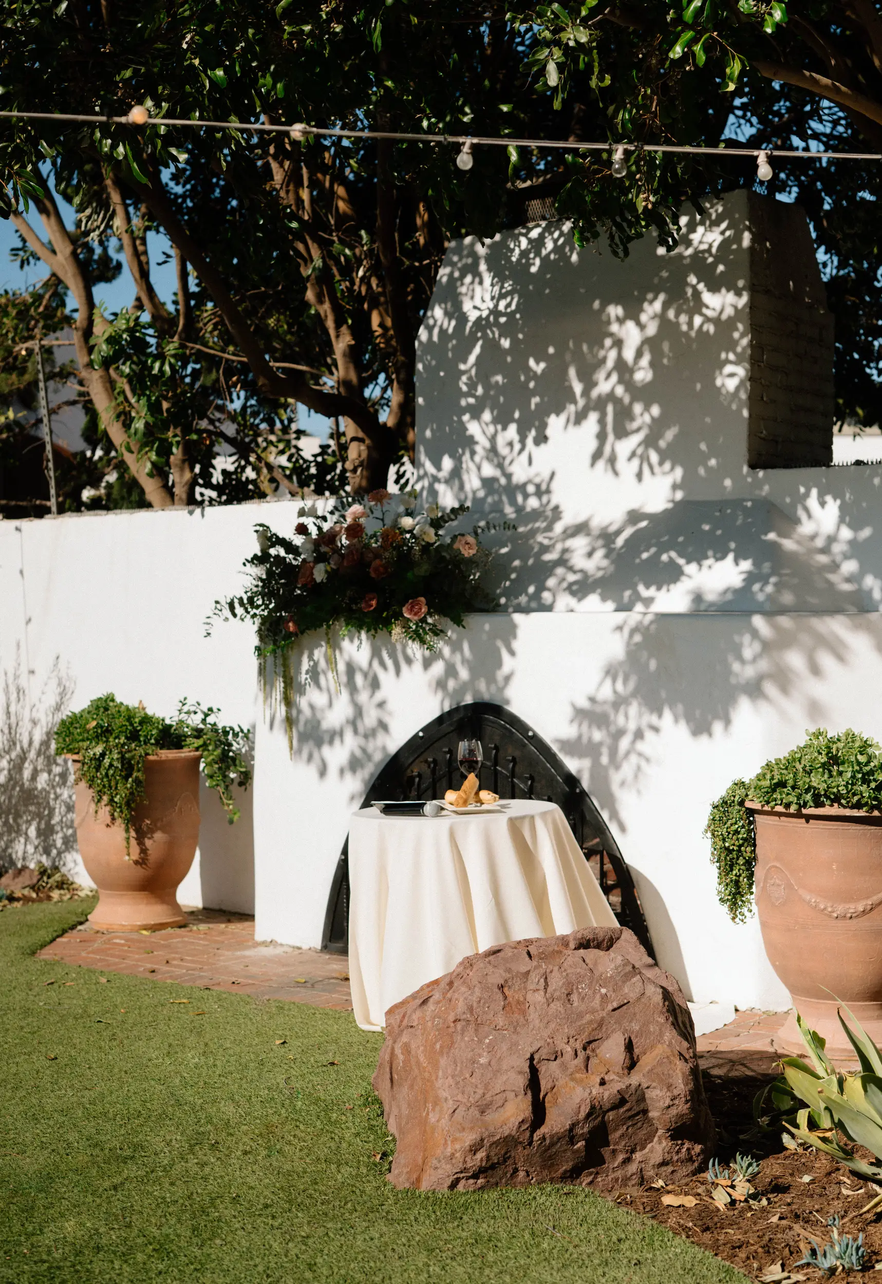 Blush florals decorate the Rock Garden mantle for the wedding ceremony backdrop.