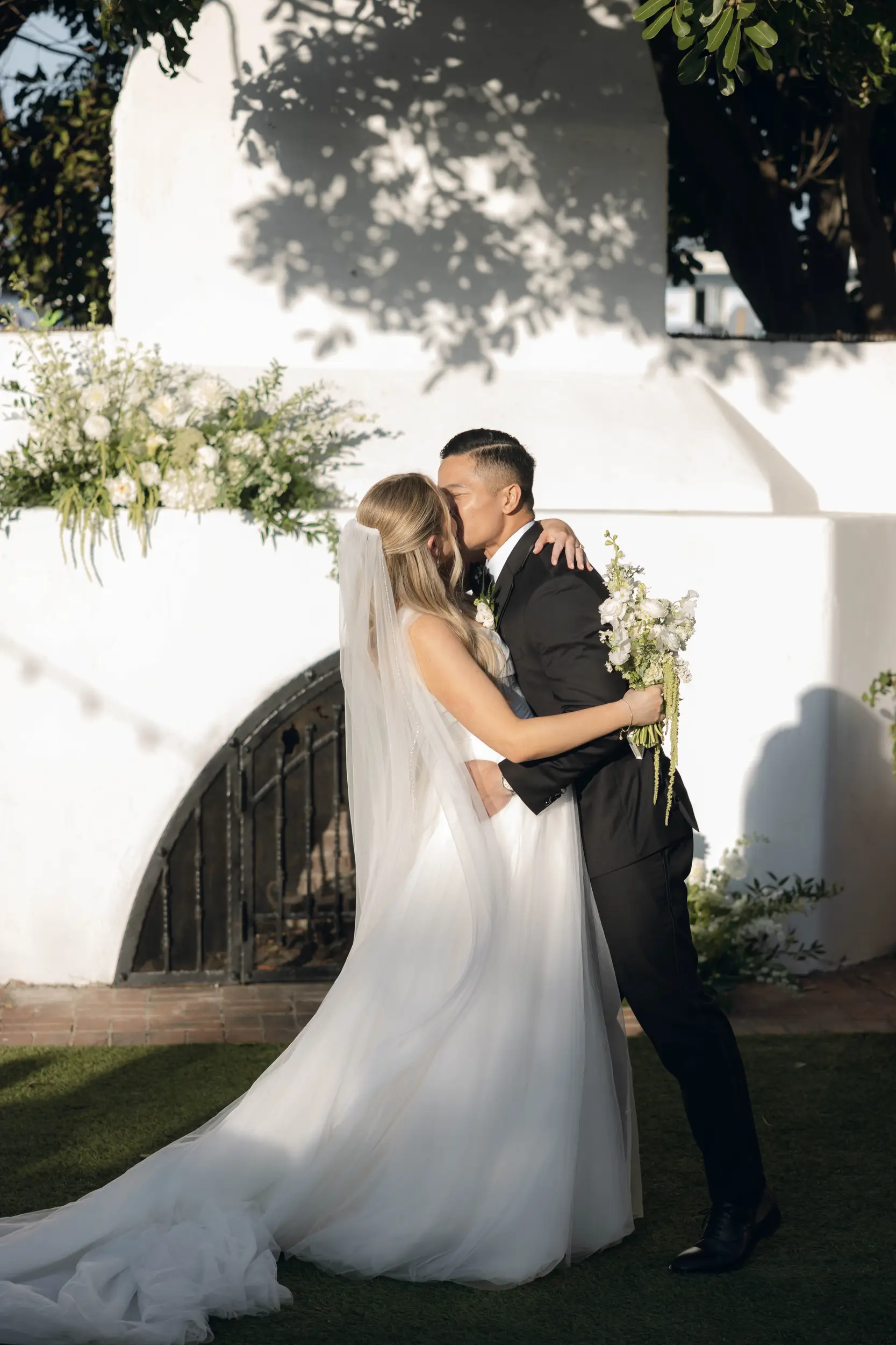Bride and groom share a ceremony kiss.