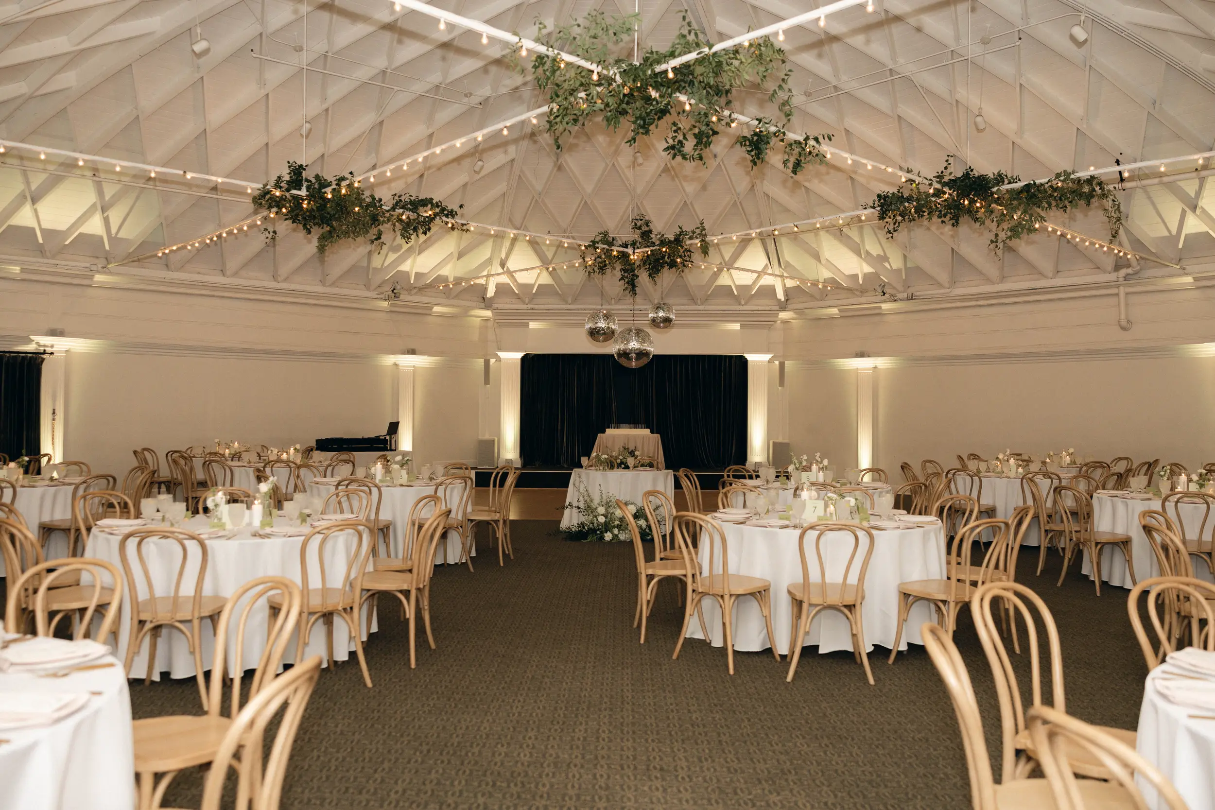 Wedding reception in the Grand Ballroom with disco balls and greenery hanging from the ceiling.