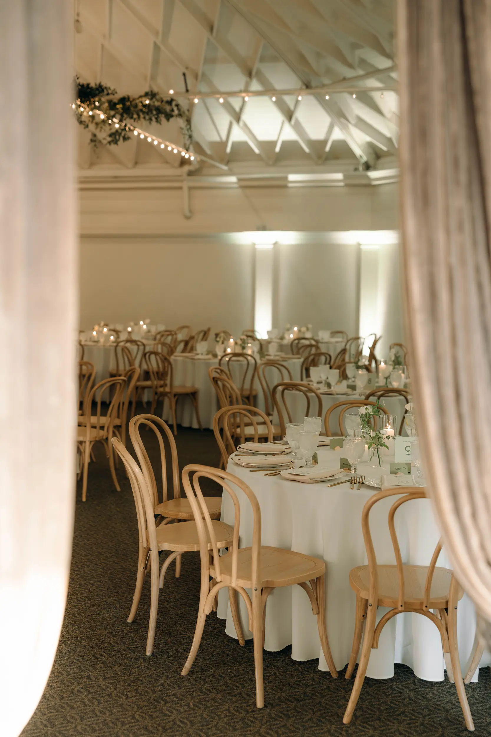 Reception tables are set with white floral centerpieces in the Grand Ballroom.