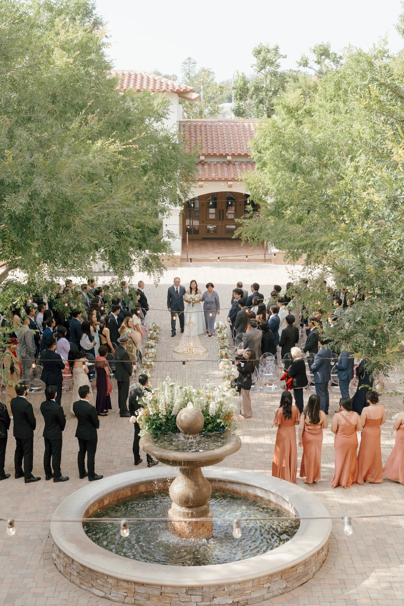 Bride walks down aisle with her parents.