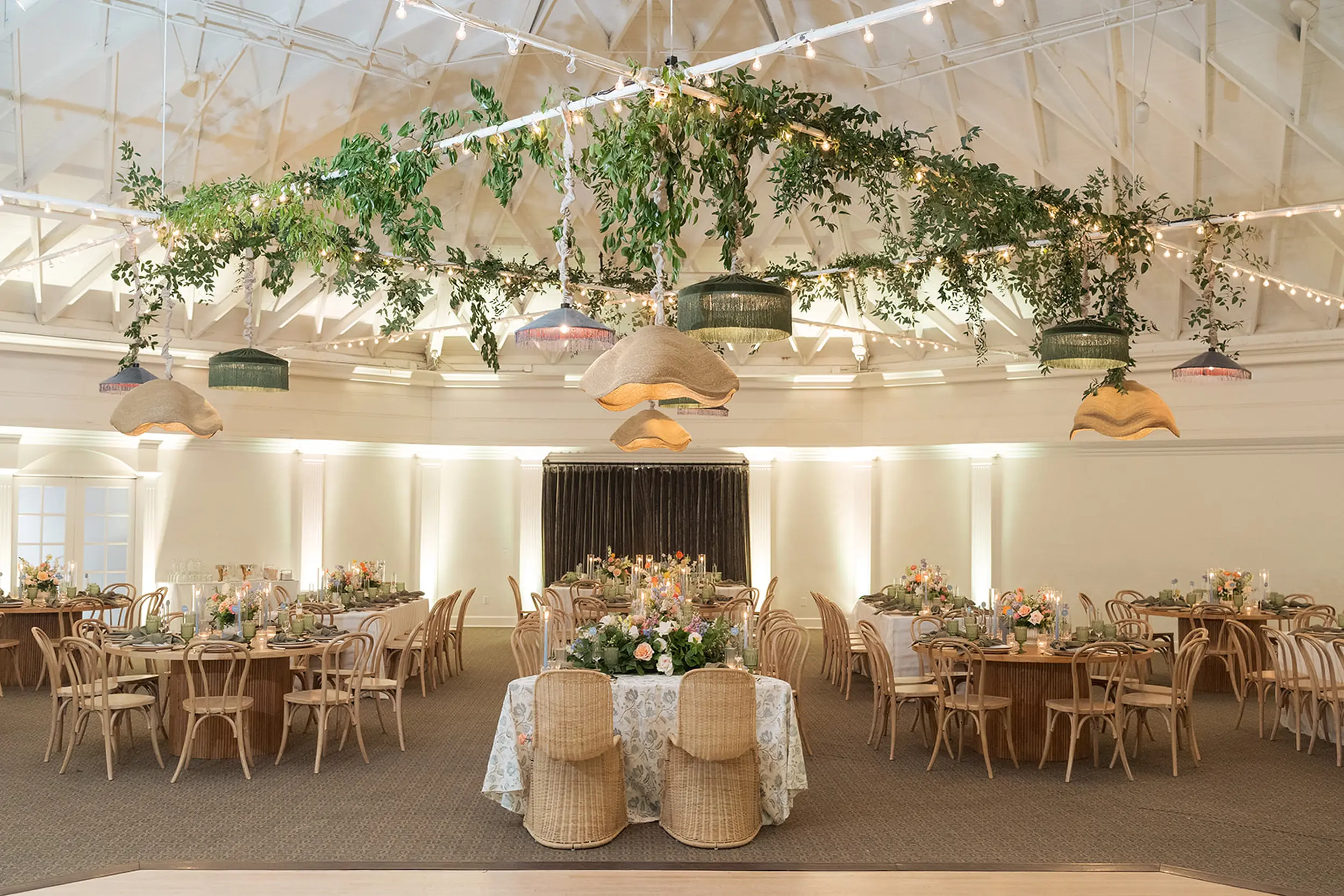 Spring pastel florals and colorful pendant lights decorate the Casino's Grand Ballroom for this wedding reception.
