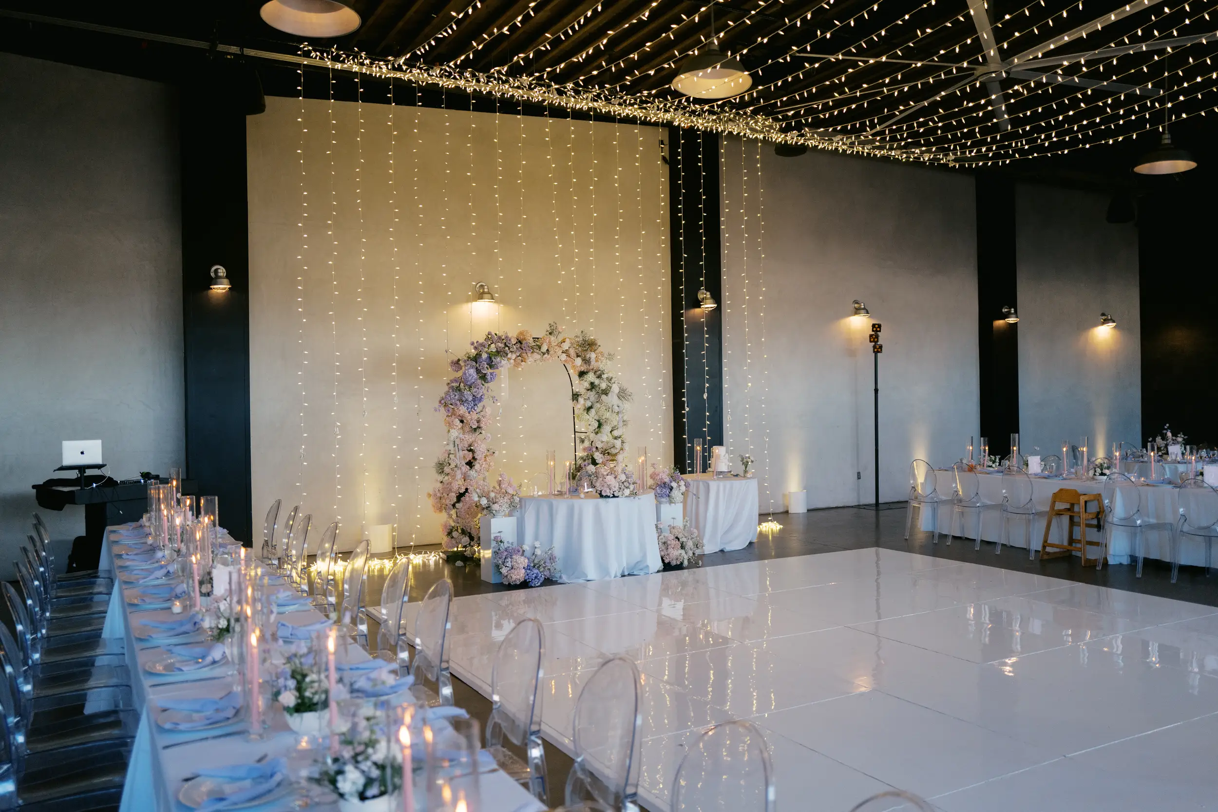 Pastel pink and purple flowers decorate the hangar for a spring wedding.
