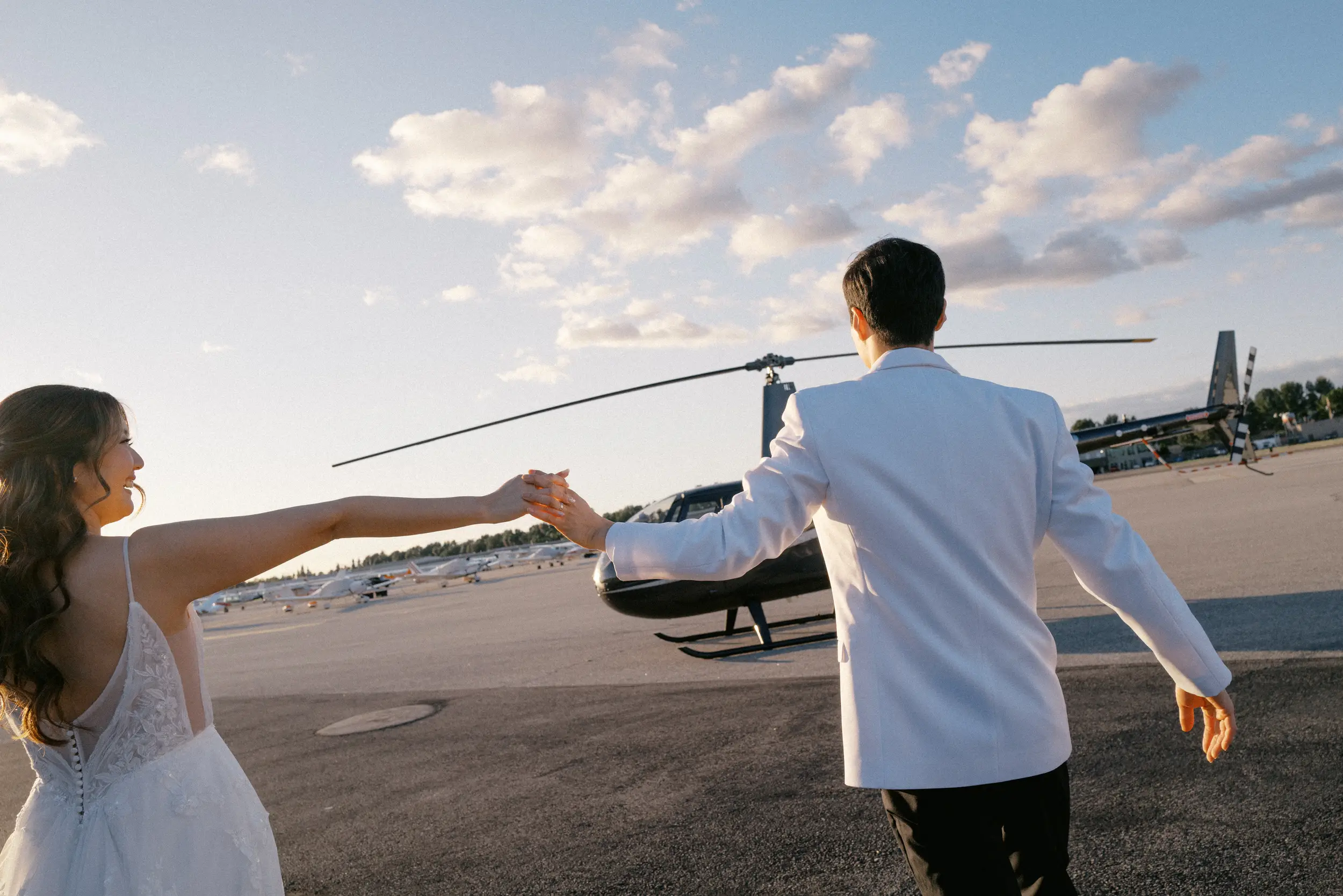 Bride and groom walk on the tarmac to their helicopter flight.