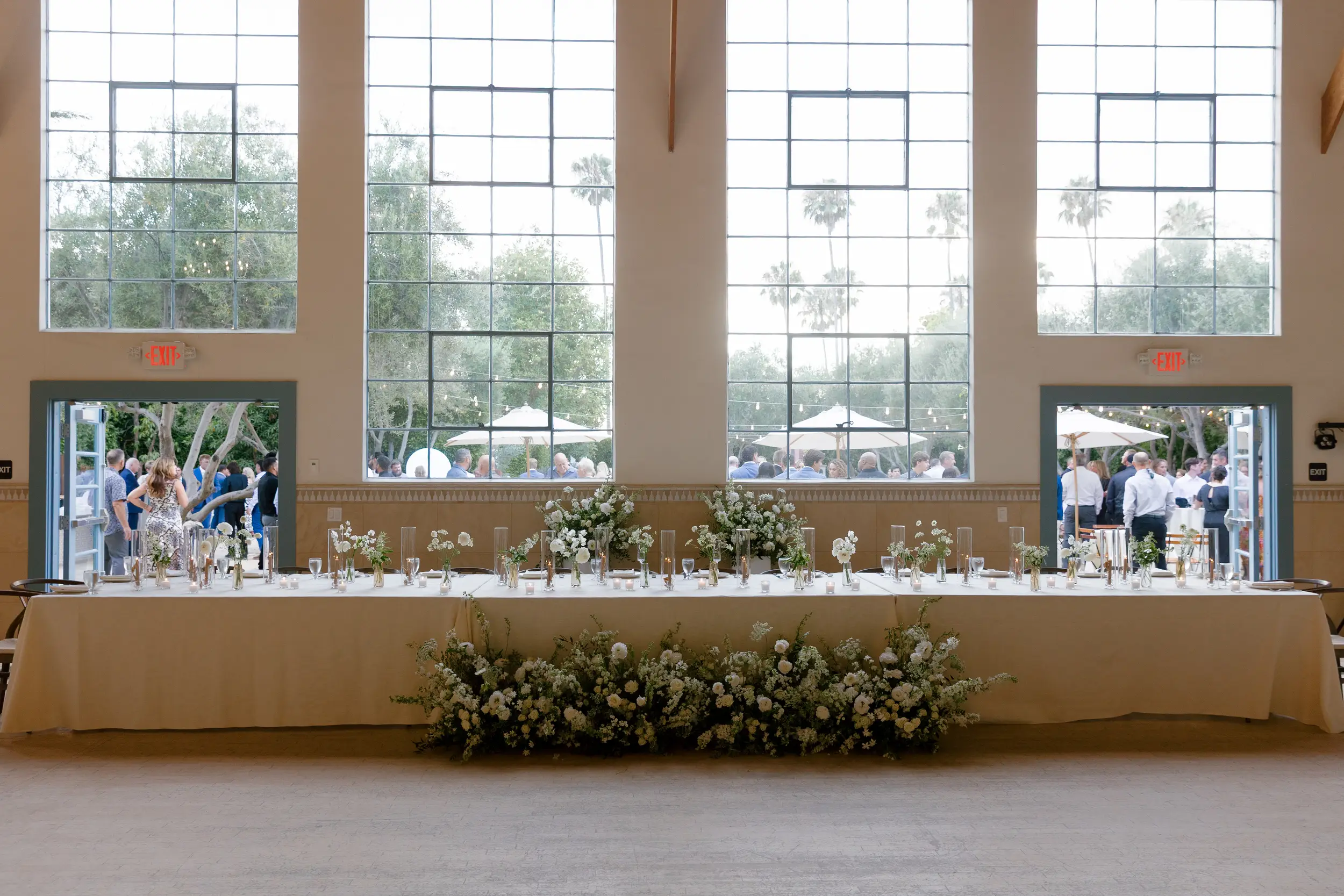 Indoor wedding reception with taupe candlesticks and white floral arrangements.