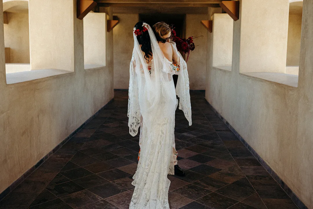 Wedding couple embracing in Serra Plaza's covered walkway.