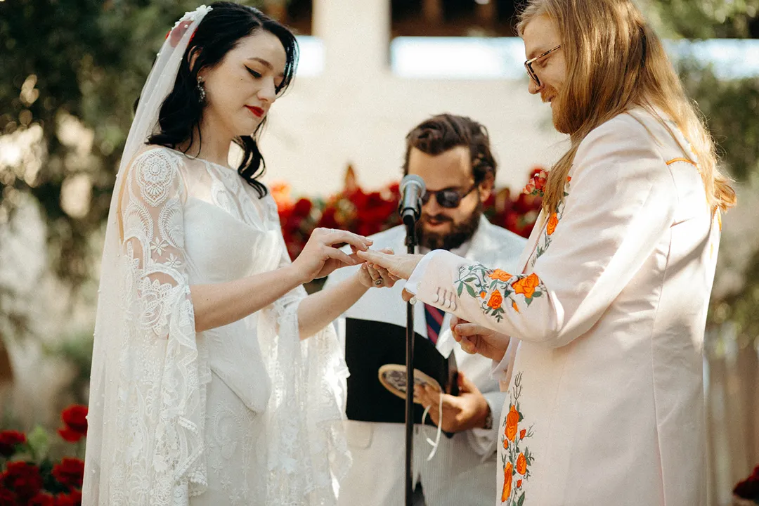 Wedding couple exchanging rings during their courtyard ceremony.