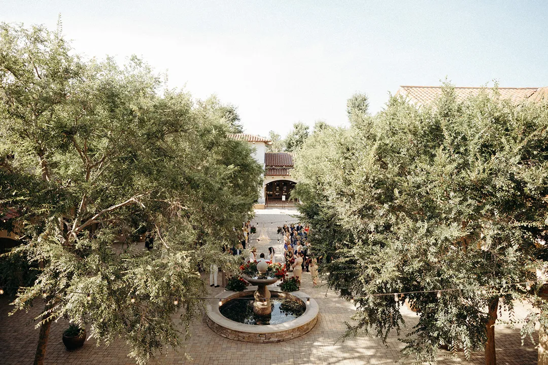 Elevated view of Serra Plaza's courtyard fountain beneath leafy trees.