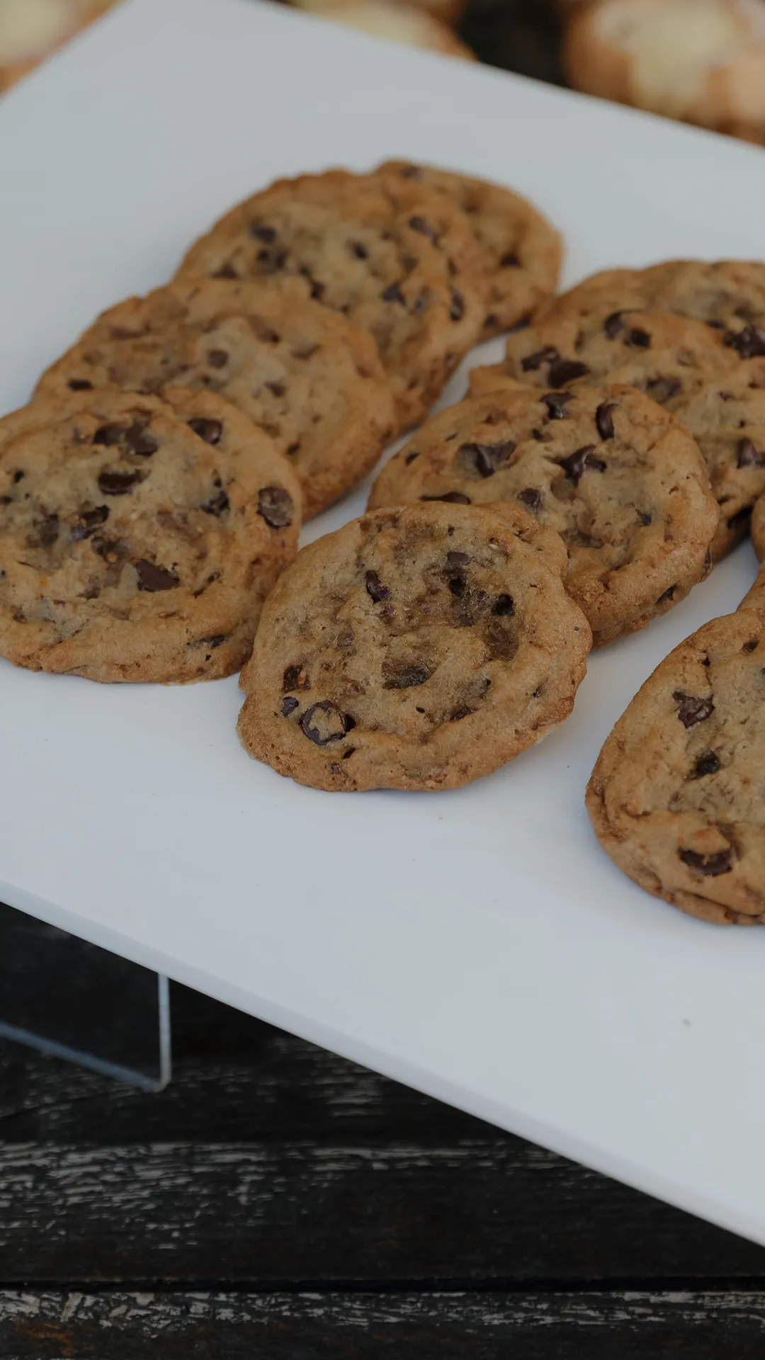 Chocolate chip cookies arranged on a white platter.
