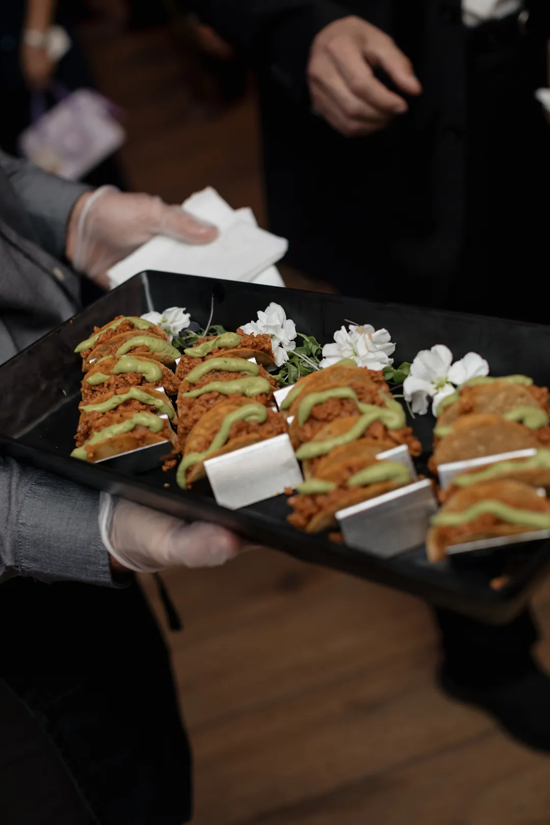 Tray of miniature tacos topped with avocado.