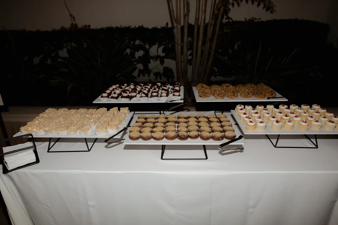 Assorted miniature desserts displayed on raised trays at the reception.