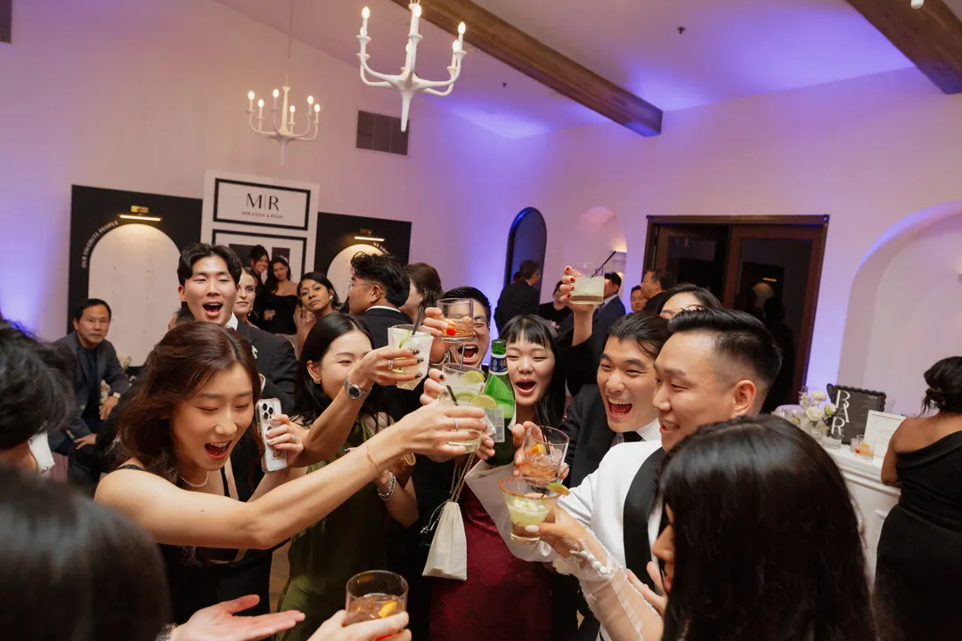 Wedding guests raising their glasses together during cocktail hour.