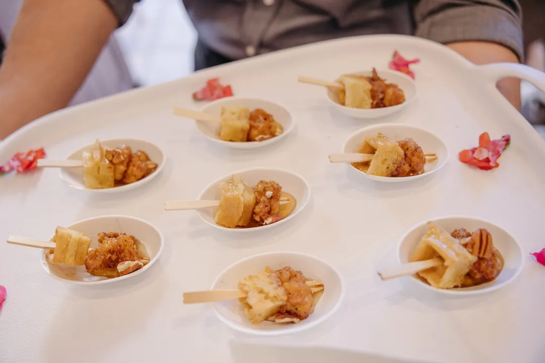 Mini chicken-and-waffle bites served on tasting spoons.