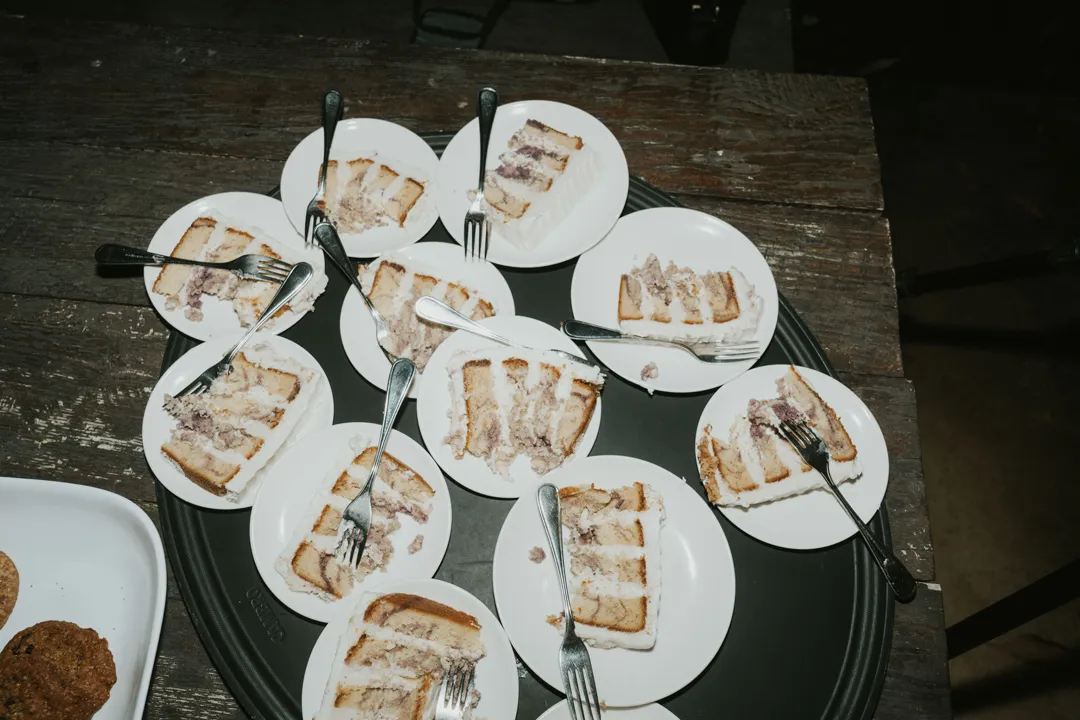 Slices of wedding cake plated with forks for guests.