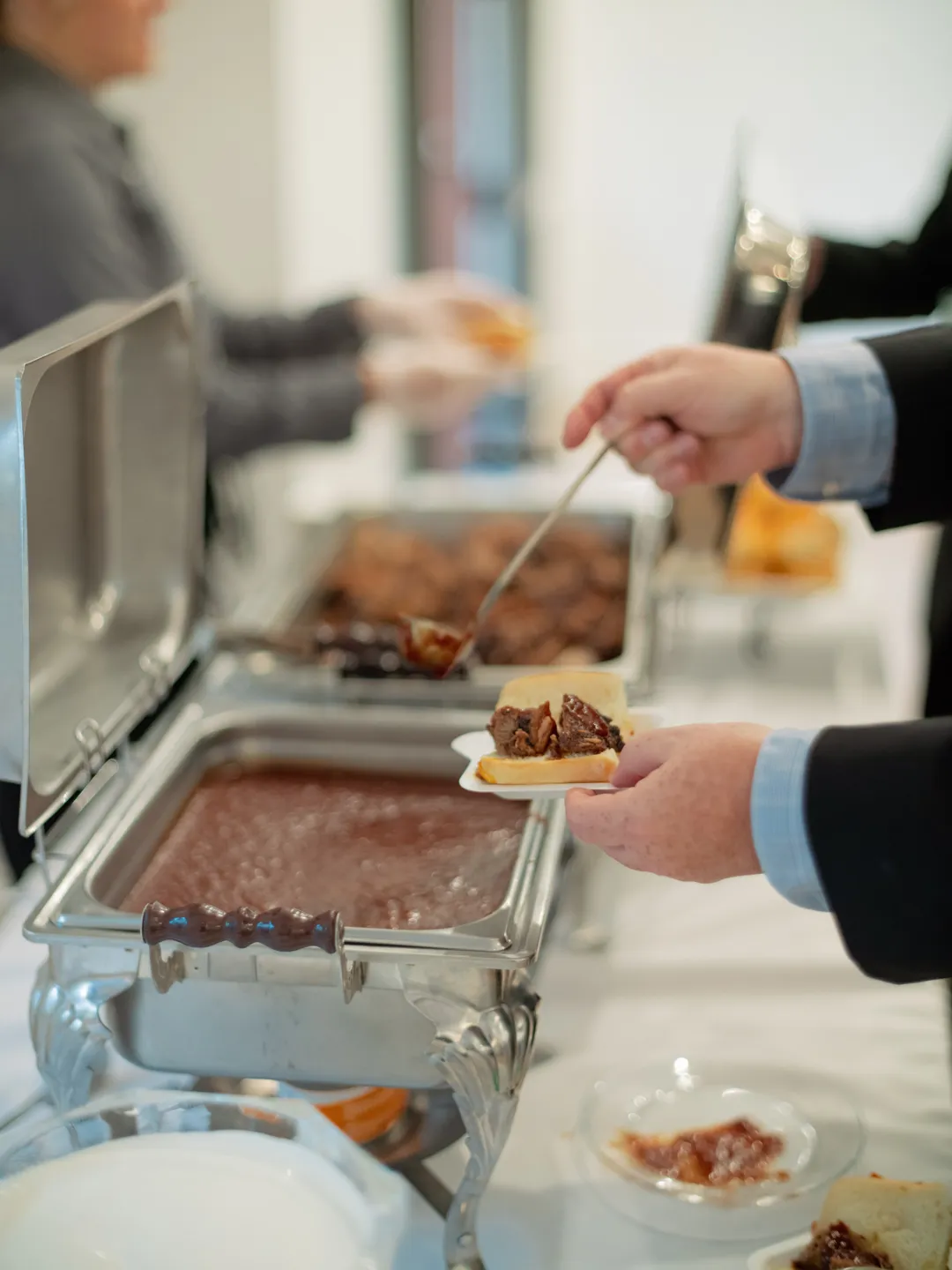 Guest serving a small plate from the catering buffet.