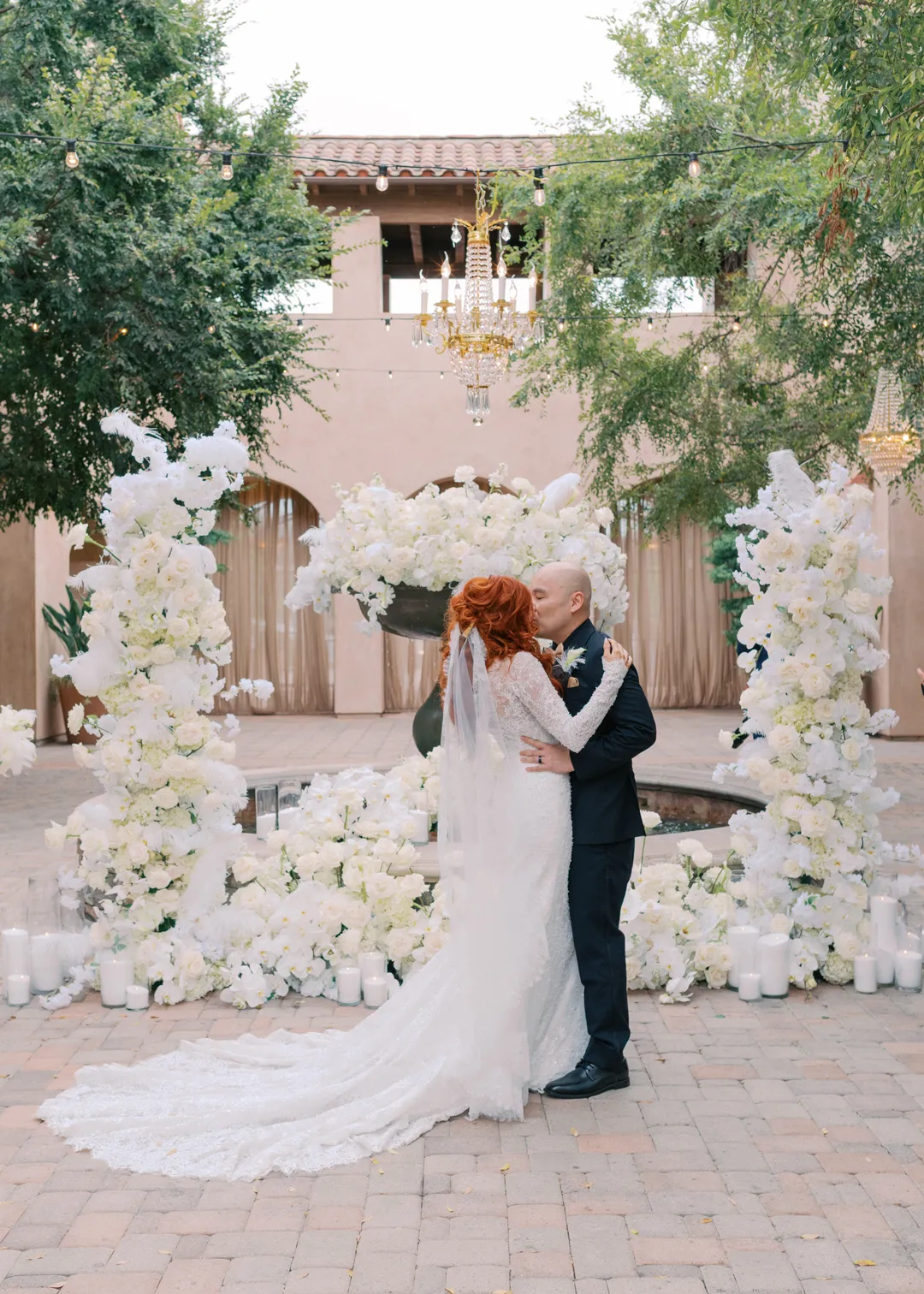 Wedding couple kissing beside the fountain at the end of their ceremony.
