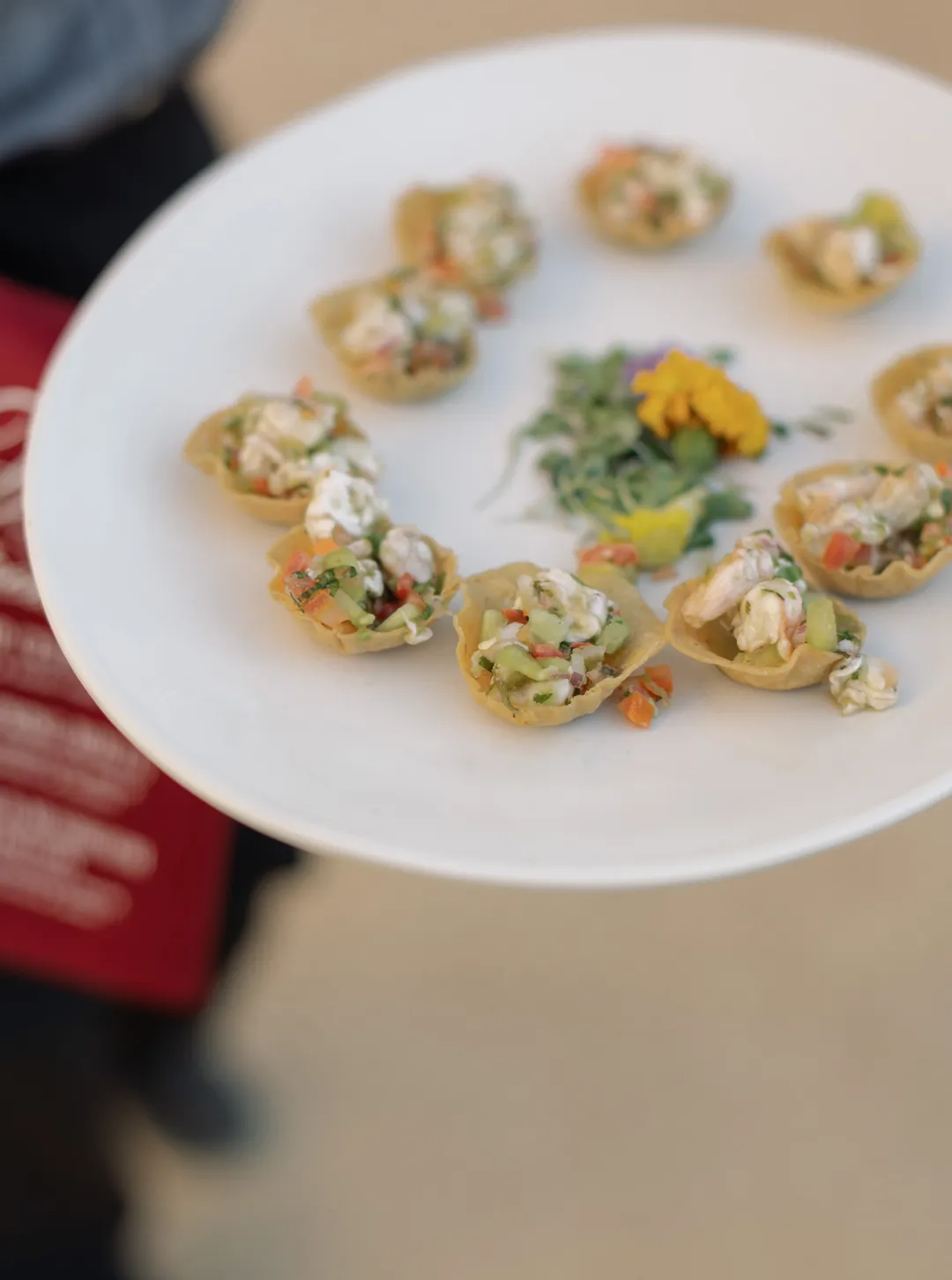 Small filled appetizer cups arranged on a white serving platter.